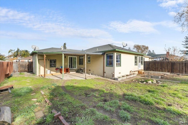 rear view of property featuring a lawn and a patio area