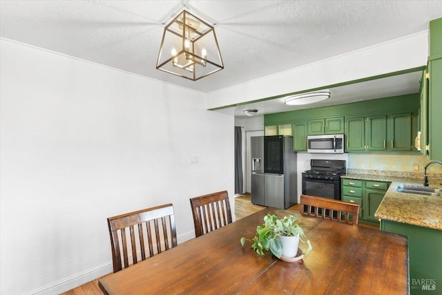 dining area featuring a textured ceiling, a notable chandelier, sink, and dark wood-type flooring