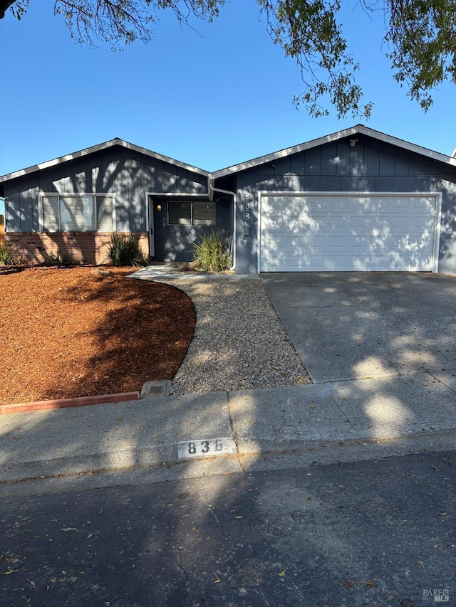 mid-century home featuring a garage and driveway