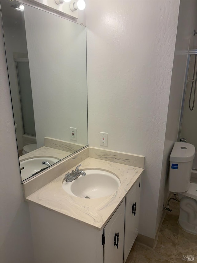 bathroom with a shower, vanity, toilet, and tile patterned floors