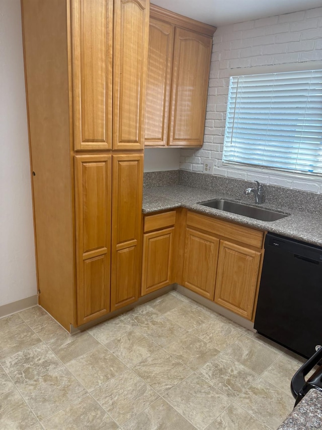 kitchen featuring black dishwasher, brown cabinets, and a sink