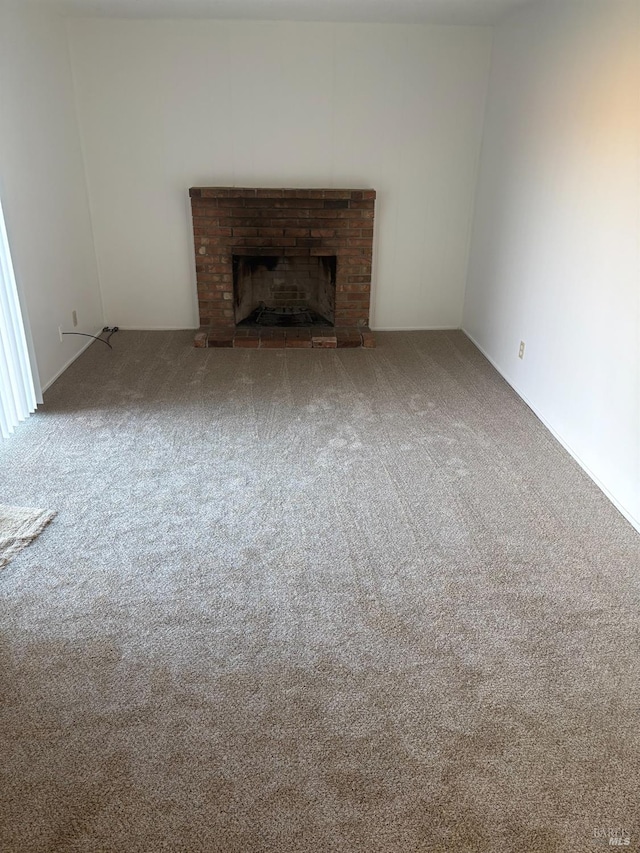 unfurnished living room with a fireplace and carpet flooring