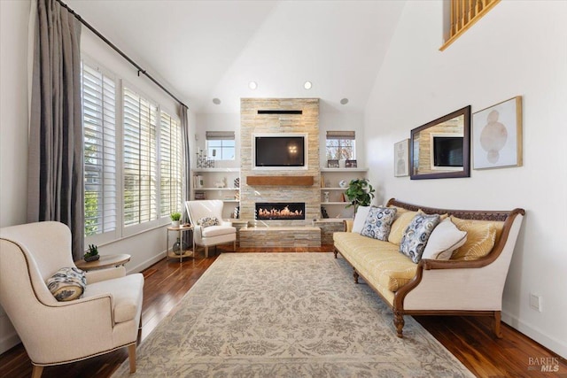 living room featuring high vaulted ceiling, dark hardwood / wood-style floors, and a fireplace