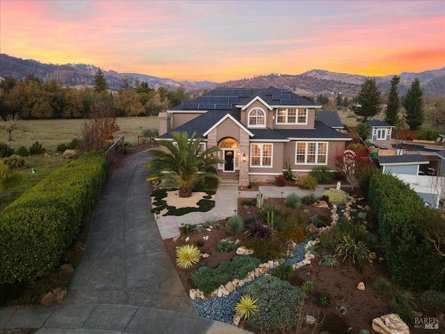 view of front of home featuring a mountain view and solar panels