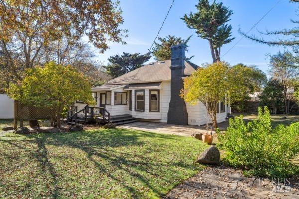 rear view of house featuring a lawn and a wooden deck