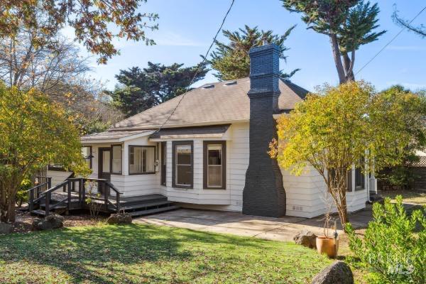 back of property featuring a deck, a patio, and a yard