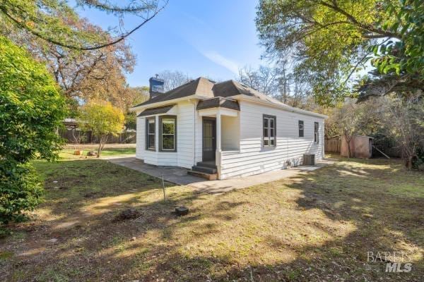 view of front of property featuring central AC unit and a front lawn