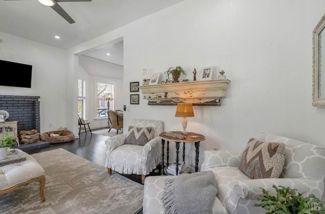 living room featuring ceiling fan and dark wood-type flooring