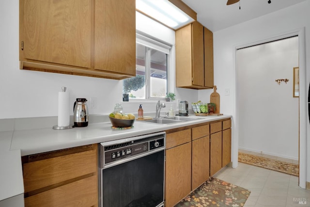 kitchen with ceiling fan, sink, light tile patterned floors, and black dishwasher