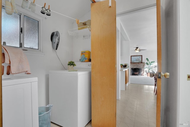 washroom featuring a brick fireplace, ceiling fan, and washing machine and clothes dryer