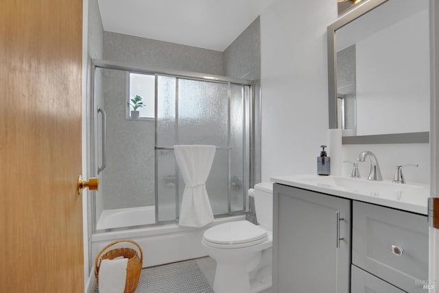 full bathroom featuring tile patterned floors, vanity, toilet, and shower / bath combination with glass door