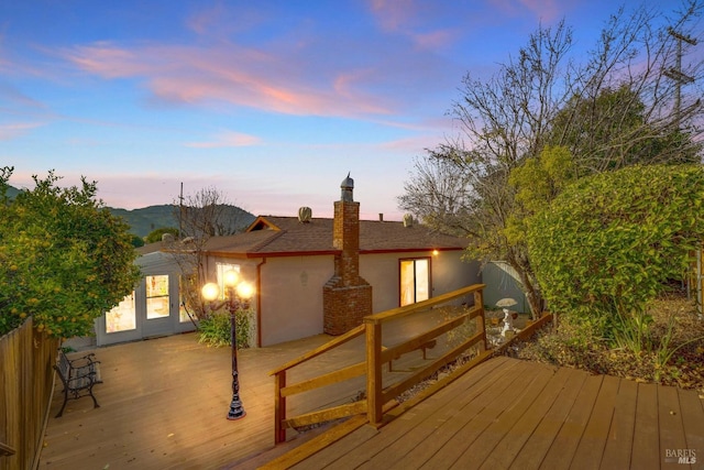 deck at dusk featuring french doors