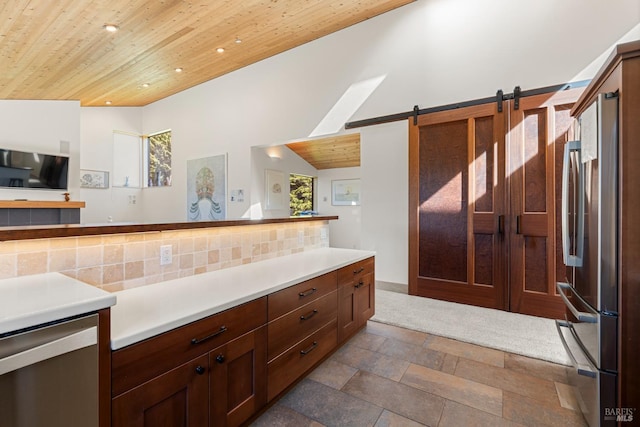 kitchen with decorative backsplash, stainless steel fridge, a barn door, high vaulted ceiling, and wooden ceiling