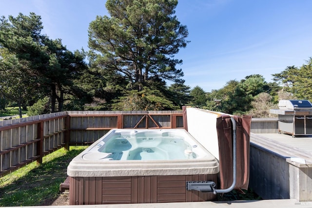 deck featuring a grill and a hot tub