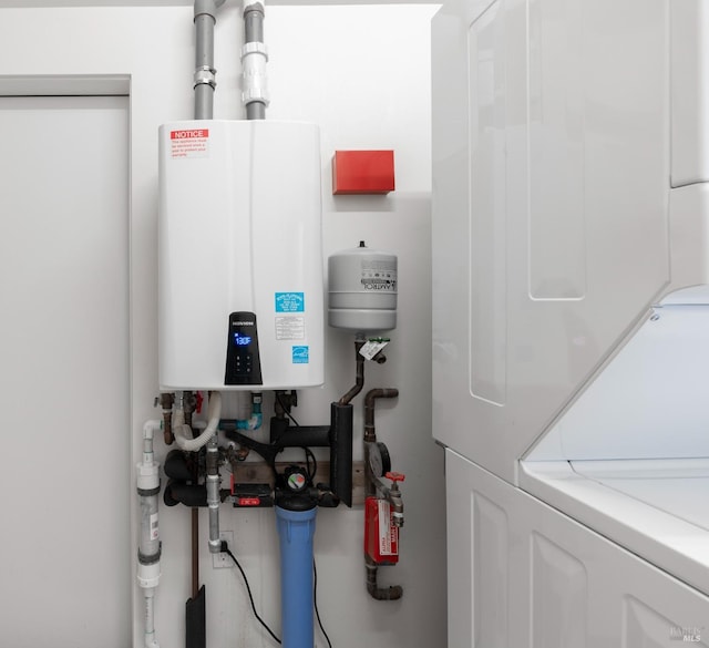 utility room featuring water heater and stacked washing maching and dryer