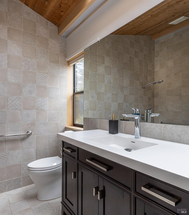 bathroom featuring vanity, vaulted ceiling, tile walls, tile patterned flooring, and toilet