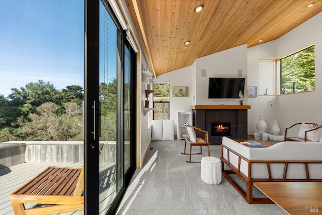 sunroom / solarium featuring lofted ceiling, wooden ceiling, and a tiled fireplace