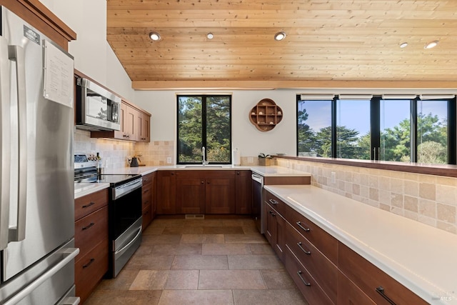 kitchen featuring wooden ceiling, sink, vaulted ceiling, decorative backsplash, and stainless steel appliances