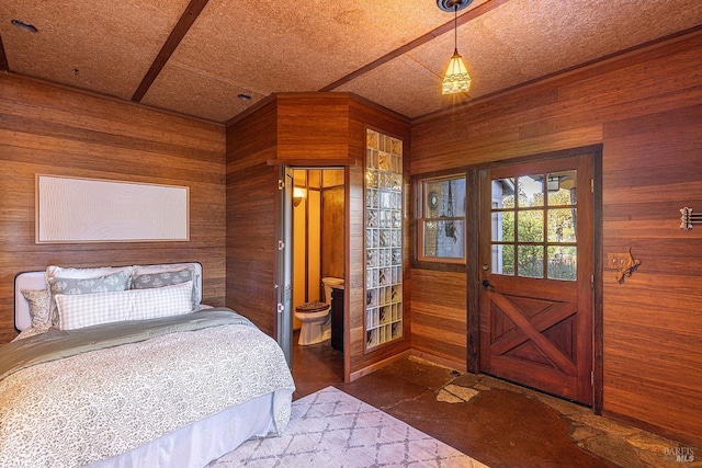 bedroom with wooden walls and connected bathroom