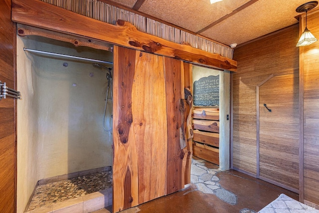 bathroom with concrete flooring and wooden walls