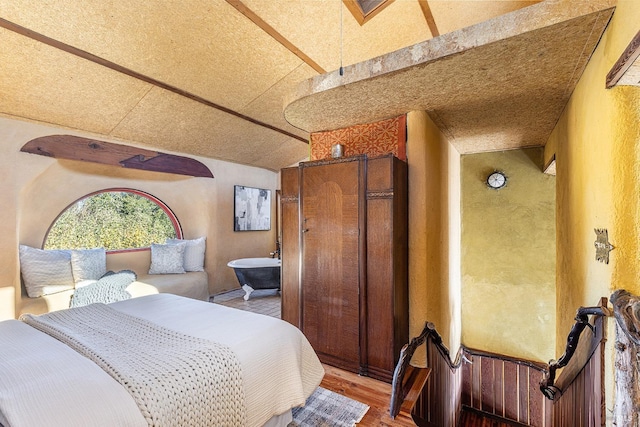 bedroom with lofted ceiling and wood-type flooring