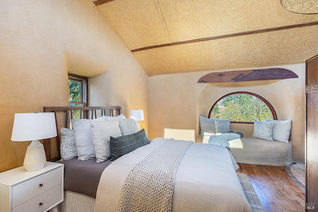 bedroom with hardwood / wood-style floors and vaulted ceiling