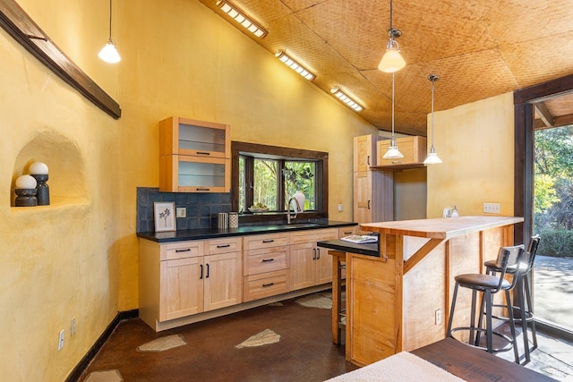 kitchen featuring a kitchen bar, a high ceiling, and decorative light fixtures