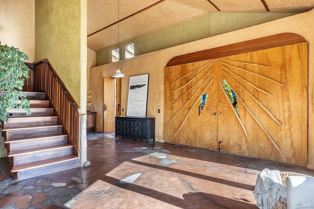 entrance foyer featuring high vaulted ceiling