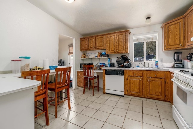 kitchen with white appliances, sink, and light tile patterned floors