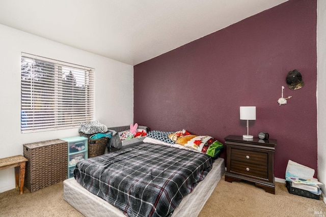 bedroom featuring light colored carpet and vaulted ceiling