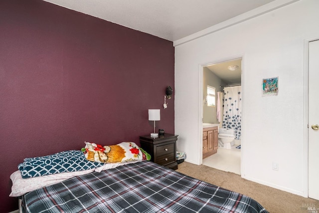 bedroom with light colored carpet and ensuite bath