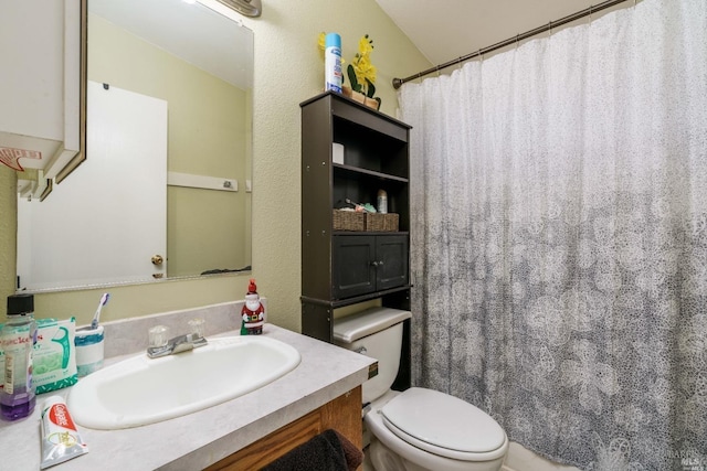 bathroom with vanity, vaulted ceiling, and toilet