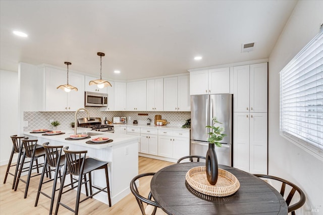 2221 Adrian St, Napa, CA 94558 - kitchen featuring stainless steel appliances, light wood finished floors, a peninsula, white cabinetry, and recessed lighting