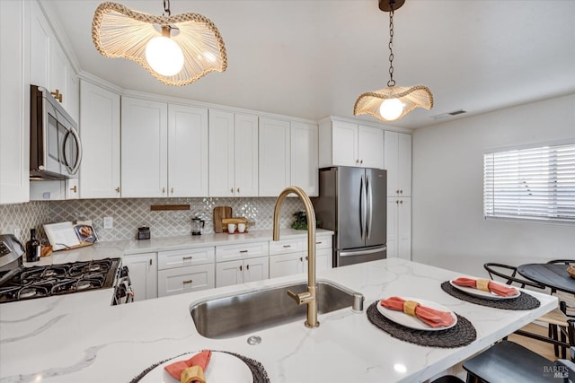2221 Adrian St, Napa, CA 94558 - kitchen with appliances with stainless steel finishes, a kitchen breakfast bar, decorative backsplash, decorative light fixtures, and white cabinets