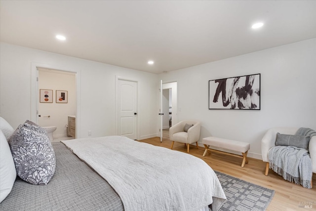 bedroom featuring hardwood / wood-style floors and ensuite bath