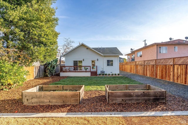 rear view of property with a lawn and a deck