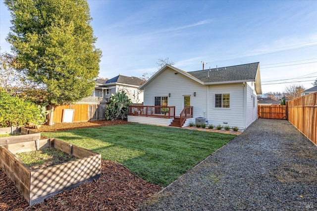 rear view of property featuring central AC, a wooden deck, and a lawn