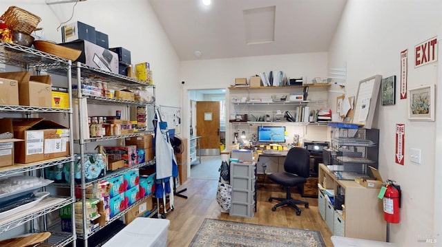 office with lofted ceiling and light hardwood / wood-style flooring