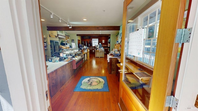 hall with hardwood / wood-style floors and rail lighting