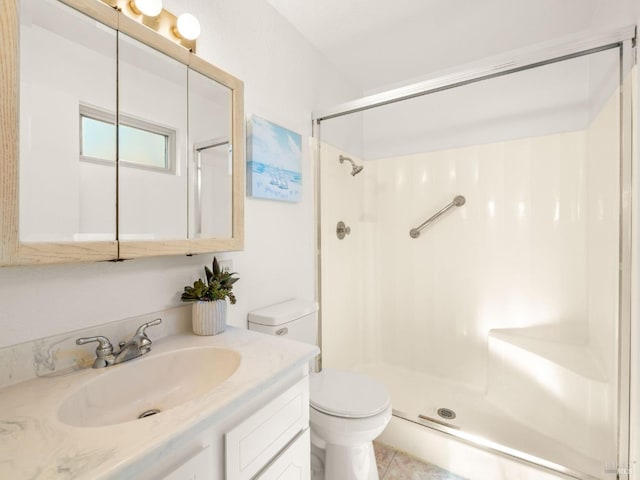 bathroom featuring tile patterned floors, toilet, vanity, and walk in shower