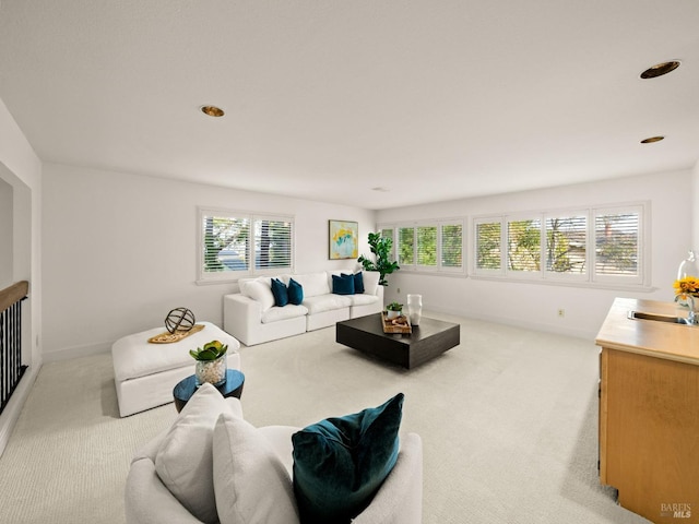 carpeted living room featuring plenty of natural light and sink