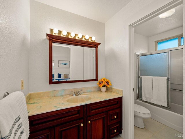 bedroom with light colored carpet, multiple closets, and ensuite bath