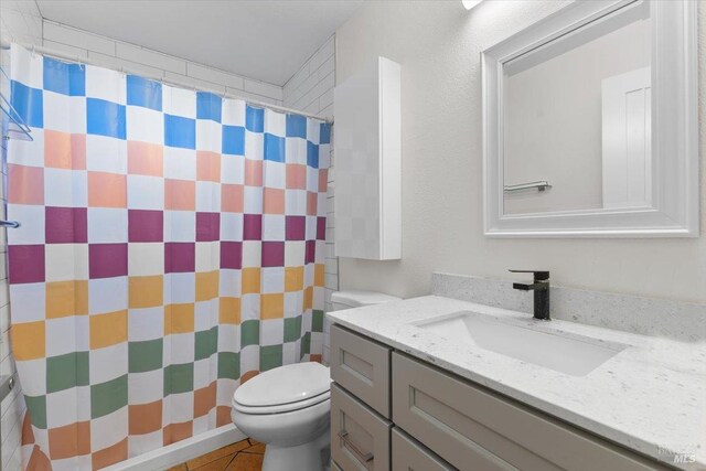 bathroom featuring tile patterned floors, vanity, curtained shower, and toilet