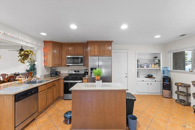 kitchen featuring light stone countertops, light tile patterned floors, sink, and appliances with stainless steel finishes