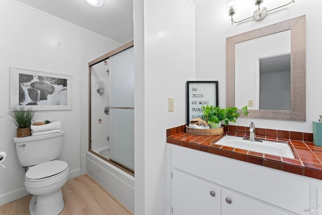 full bathroom with toilet, enclosed tub / shower combo, wood-type flooring, and vanity