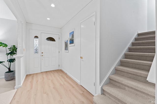 foyer entrance with ornamental molding and light hardwood / wood-style flooring