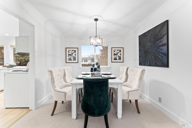 dining area with crown molding, washer / clothes dryer, and an inviting chandelier