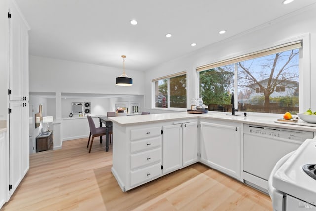 kitchen featuring white cabinetry, light hardwood / wood-style floors, sink, hanging light fixtures, and white dishwasher