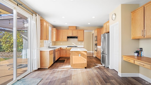 kitchen featuring a healthy amount of sunlight, a center island, light brown cabinets, and black appliances