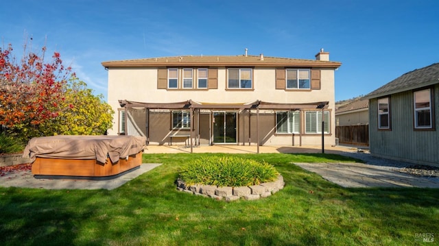 rear view of house featuring a hot tub, a patio, a yard, and a pergola